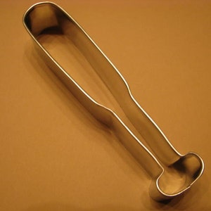 May include: A silver metal cookie cutter shaped like a baseball bat.