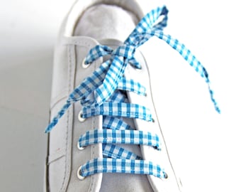 May include: White canvas sneakers with blue and white gingham ribbon laces tied in a bow.