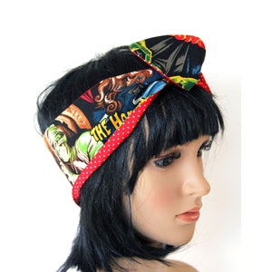 May include: A red and black headband with a white polka dot pattern. The headband features a print of a vintage movie poster with the text "The Horror of Dracula".