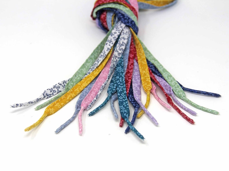 May include: A bundle of colorful shoelaces with a floral pattern. The shoelaces are made of fabric and are tied together at the top.