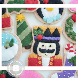 Puede incluir: Ocho adornos navideños de fieltro con varios diseños, incluyendo un muñeco de nieve, un árbol de Navidad, un cascanueces, un pingüino y una corona. Los adornos son todos beige con detalles de fieltro de colores.