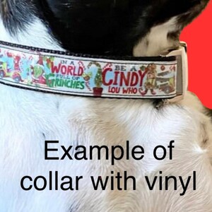 May include: A festive dog collar with a colorful design featuring characters and phrases from a holiday story. The collar has the text "IN A WORLD FULL OF GRINCHES" and "BE A CINDY LOU WHO". The image also includes the text "Example of collar with vinyl".