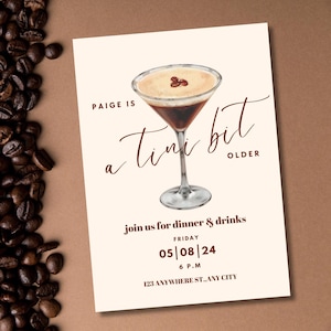 Op de afbeelding: Een beige uitnodigingskaart met bruine tekst die "Paige is een klein beetje ouder" luidt. De kaart bevat een aquarel-illustratie van een martini-glas met een koffiekleurig drankje en een bruin en wit schuimig bovendeel. De tekst bevat ook de datum "05|08|24" en de tijd "6 P.M.".