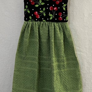 May include: A green kitchen towel with a black and red cherry print hanging loop.