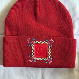 Hand embroidered knit beanie - red with geometric designs, leather smiley face patch