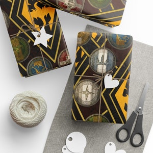 Op de afbeelding: Drie cadeaudozen ingepakt in bruin en goud cadeaupapier met een patroon van schilden en wapens. Het papier heeft een middeleeuws thema.
