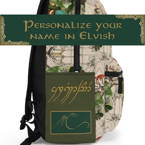 May include: A black backpack with a white and green pattern featuring a dragon and a forest scene. The backpack has a zippered pocket with a gold inscription in Elvish script. The text "Personalize your name in Elvish" is displayed on a green banner.
