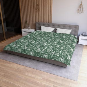 May include: A green duvet cover with a white pattern of various symbols and designs. The duvet cover is on a bed with white pillows.