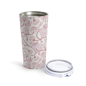 May include: A stainless steel tumbler with a white background and a pink floral pattern featuring stylized creatures. The tumbler has a lid.