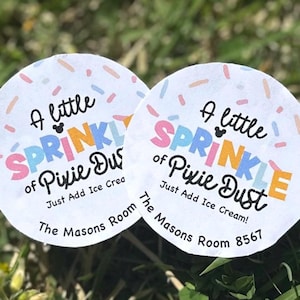 May include: Two round stickers with the text "A little sprinkle of Pixie Dust" in colorful letters. The stickers have a white background with colorful sprinkles and the text "Just Add Ice Cream!" and "The Masons Room 8567".