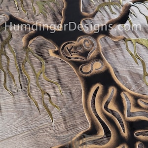 May include: A metal wall art piece depicting a stylised willow tree with a heart and infinity symbol. The tree is black with gold accents. The heart has the initials "K & C" inside.