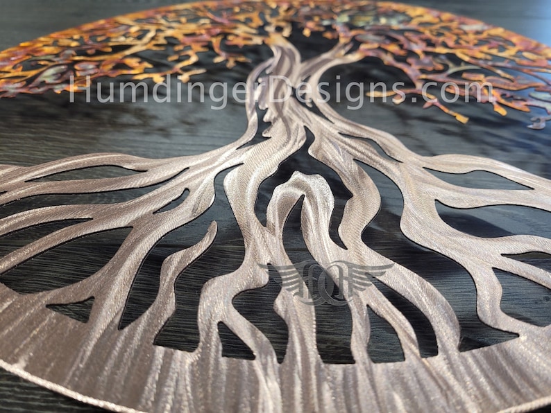 K&ouml;nnte beinhalten: Eine Wandkunst aus Metall in Form eines Lebensbaums mit einer Kupfer-Oberfl&auml;che. Der Baum hat ein detailliertes Design mit filigranen &Auml;sten und Wurzeln. Die Wurzeln sind in einem kreisf&ouml;rmigen Muster ausgebreitet.