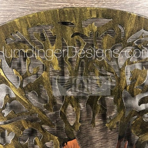 May include: A gold metal tree wall art with a cutout design. The tree is painted with a gold metallic paint and has a distressed finish.