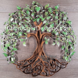 May include: A metal tree of life wall art with a green and brown patina finish. The tree has a Celtic knot design and intricate branches with leaves. The roots are intertwined and spread out at the base.