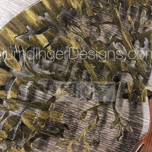 May include: A gold metal tree wall art with a brown wood base. The tree has a detailed design with intricate branches and leaves. The wall art is a decorative piece for a home or office.