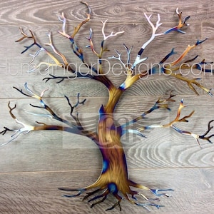 May include: A metal wall sculpture of a tree with a brown, blue, and silver finish. The tree has many branches and a thick trunk with roots. The sculpture is on a wood background.