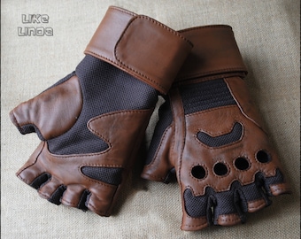 May include: A pair of brown fingerless gloves with a leather and mesh design. The gloves have a brown leather cuff with a velcro closure. The palm and finger areas have a mesh material with brown leather accents and circular cutouts.