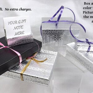 May include: Four gift boxes with different colored ribbons. The boxes are silver and black. One box has a card that says "Your Gift Note Here".