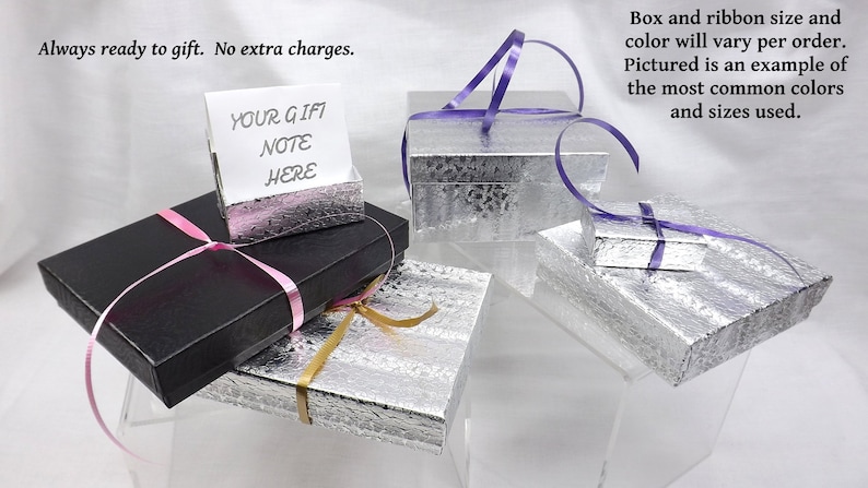 May include: Four gift boxes with different colored ribbons. The boxes are silver and black. One box has a card that says "Your Gift Note Here".