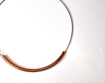 May include: A simple copper and silver choker necklace with a thin wire and a curved copper bar.