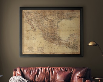 May include: A vintage map of Mexico in a brown frame hangs above a brown leather sofa with a throw blanket. A brass floor lamp and a side table with a vase are also in the room.