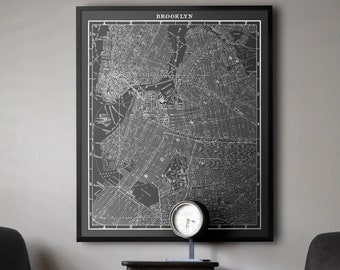 Könnte beinhalten: Eine Schwarzweiß-Vintage-Karte von Brooklyn, New York, gerahmt in einem schwarzen Rahmen und an einer Wand hängend. Zwei schwarze Leder-Sessel stehen auf beiden Seiten der Karte, mit einem kleinen Holztisch und einer Uhr dazwischen.