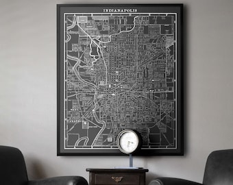 Puede incluir: Un mapa en blanco y negro de Indianápolis, Indiana, enmarcado en negro, cuelga de una pared sobre una mesa auxiliar de madera oscura con tres cajones. Dos sillones de cuero negro están colocados a cada lado de la mesa.