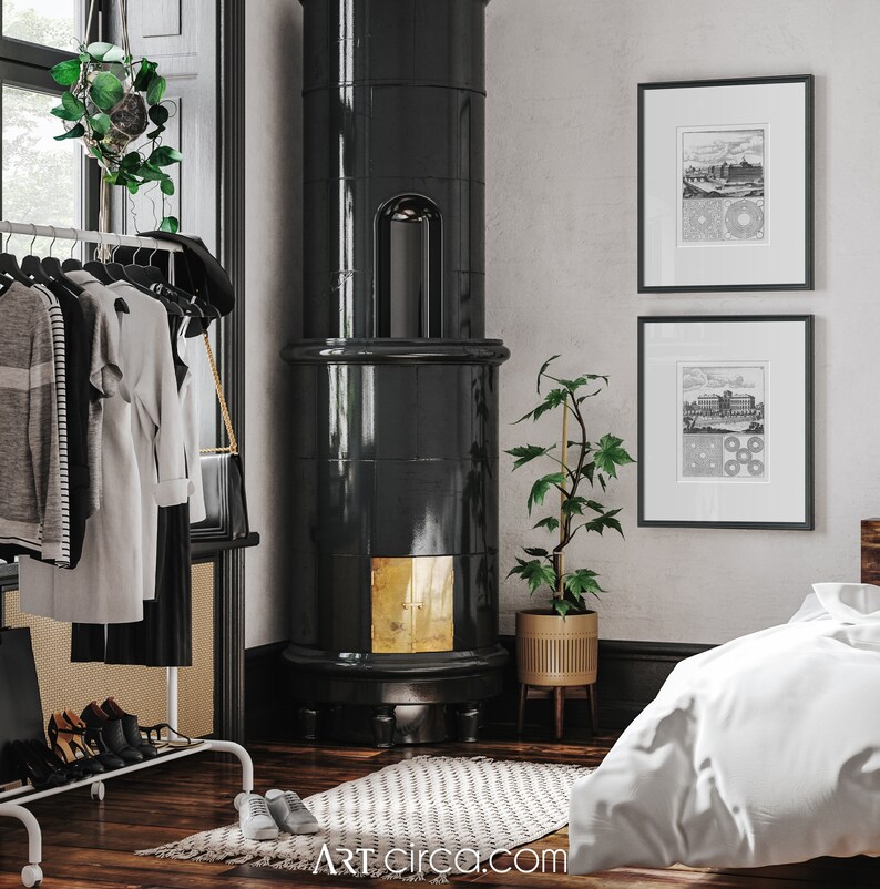 May include: A black tiled wood-burning stove with a gold trim in a room with a white rug, a potted plant, and two black framed prints on the wall.
