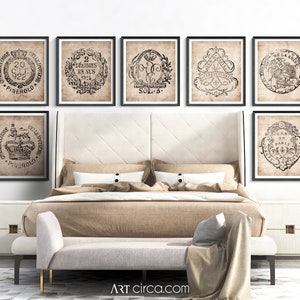 May include: A set of eight black and white vintage prints featuring ornate designs and text. The prints are framed in black and displayed on a wall above a bed with a beige headboard and a white bedspread.