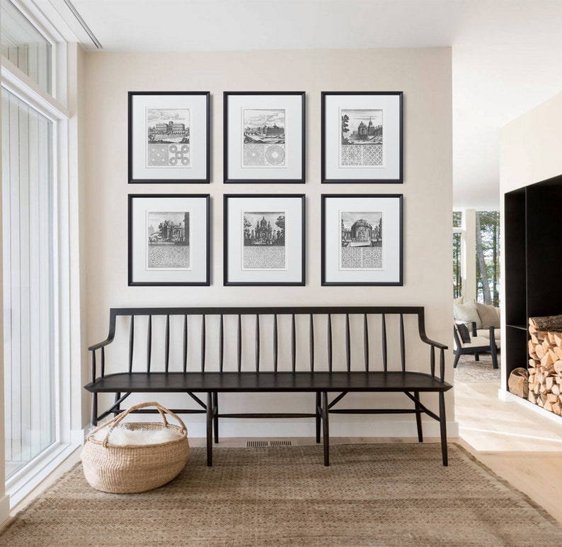May include: A black wooden bench with a white fluffy cushion in a basket sits in front of a wall with six black framed prints of vintage illustrations. The prints are arranged in a grid pattern.