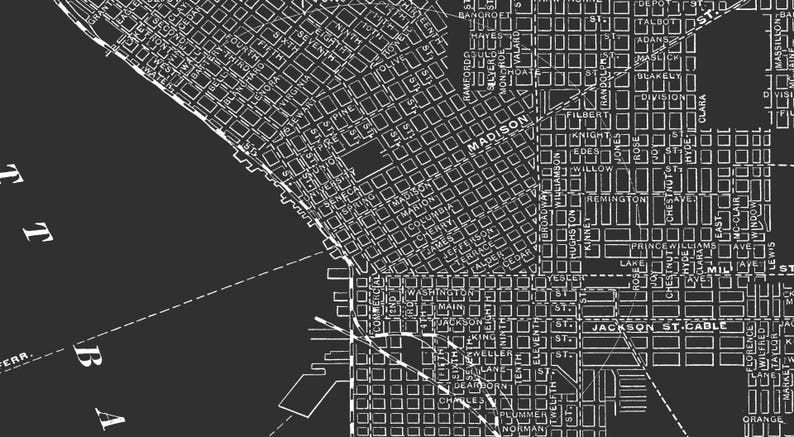 May include: A black and white map of a city with street names and grid layout. The map shows the streets of Seattle, Washington, USA. The map includes street names like Madison Street, Jackson Street, and Pike Street.