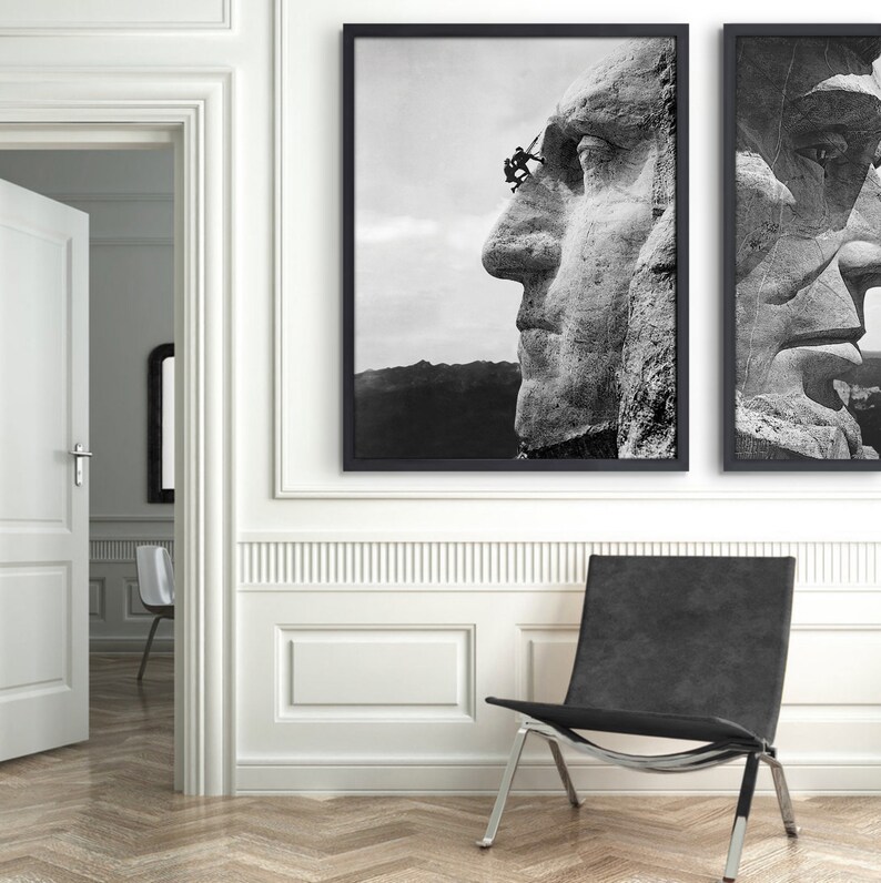 May include: Two black and white framed photographs of Mount Rushmore National Memorial. The left photo shows a close-up of the face of George Washington, with workers scaling the mountainside. The right photo shows a close-up of the face of Abraham Lincoln.