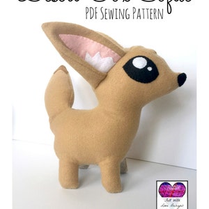 Peut inclure: Un renard du d&eacute;sert en feutre beige, avec de grands yeux noirs, un nez noir et de grandes oreilles avec des d&eacute;tails int&eacute;rieurs roses et blancs. Le texte "Desert Fox Softie PDF Sewing Pattern" est &eacute;crit en noir en haut de l'image.