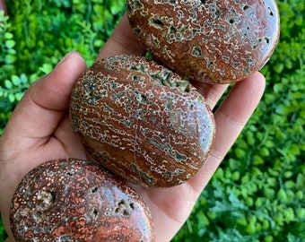 Può includere: Tre pietre lisce e levigate con un motivo unico e vorticoso di marrone, rosso e verde. Le pietre hanno una forma ovale e hanno un aspetto naturale e terroso.
