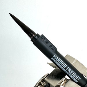 Puede incluir: Un destornillador anti-rodadura negro Harbor Freight con el texto "Harbor Freight Quality Tools Lowest Prices" impreso en el lateral.