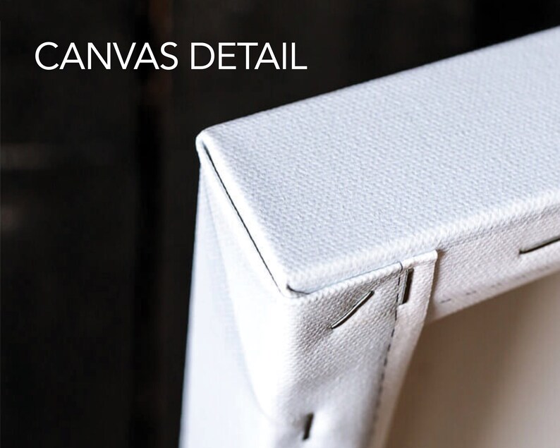 May include: Close-up of a white canvas print, showing the edge of the canvas and the staples holding it in place. The canvas is stretched tightly over a wooden frame.