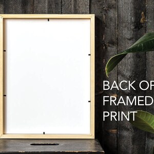 May include: The back of a framed print with a light wood frame. The print is white and the frame is a natural wood color. The text "BACK OF FRAMED PRINT" is printed in black on a dark wood background.