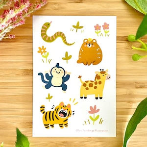 Puede incluir: Un conjunto de pegatinas de animales coloridos que incluyen una serpiente, un mono, un oso, una jirafa y un tigre. Las pegatinas están sobre un fondo blanco con flores verdes y rosas.