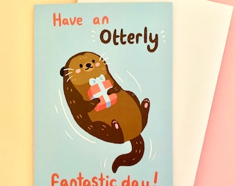 May include: A blue greeting card with a cartoon otter holding a gift. The card says "Have an Otterly Fantastic Day!"
