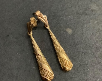 May include: A pair of gold dangle earrings with a swirl design. The earrings have a simple, elegant design.
