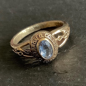 May include: A gold class ring with a blue oval stone and the inscription "Strong College".