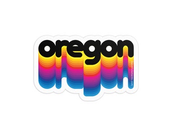 May include: A sticker with the word "oregon" in black letters with a rainbow-colored background. The sticker has a white border.