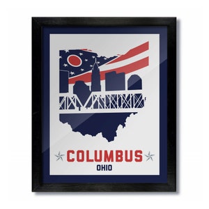 May include: A framed print of the Columbus, Ohio skyline with a red, white, and blue American flag overlayed on the state of Ohio. The text "COLUMBUS OHIO" is printed below the skyline.