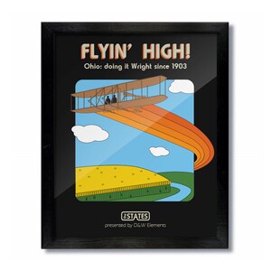 May include: A black framed poster with a retro illustration of a biplane flying over a field with a rainbow trail. The text on the poster reads "FLYIN' HIGH! Ohio: doing it Wright since 1903" and "#STATES presented by D&W Elements".
