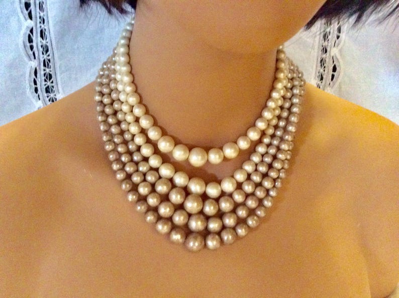 Four strands of neutral creams and champagne colored beaded bib necklace Lovely midcentury classic perfect with any outfit.
