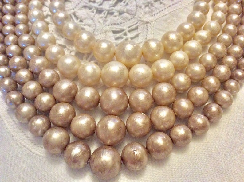 Four strands of neutral creams and champagne colored beaded bib necklace Lovely midcentury classic perfect with any outfit.