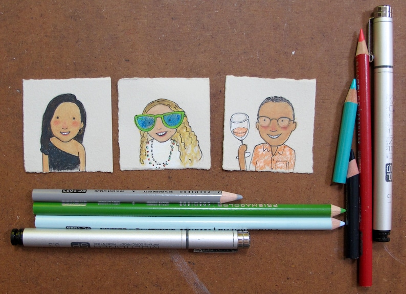 May include: Three hand-drawn illustrations on paper, each depicting a person. The first person is a woman with long black hair wearing a black dress. The second person is a woman with long blonde hair wearing sunglasses and a necklace. The third person is a man with short brown hair wearing a light orange shirt and glasses. The illustrations are surrounded by colored pencils and a silver pen.