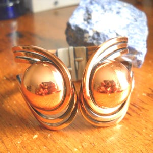 Puede incluir: Una taza de cerámica blanca con un asa negra y el texto "But first, coffee" en un estilo manuscrito. La taza está sobre una superficie blanca.