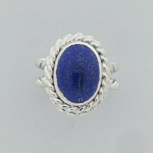 Puede incluir: Un anillo de plata con una piedra de lapisl&aacute;zuli azul engastada en un dise&ntilde;o de cuerda.