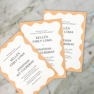 May include: Peach-colored wedding invitation with a wavy border. The invitation reads "The Doctors Loma invite you to celebrate the wedding of Kellen Emily Loma to Jonathan Kit Courdray" and includes the date, time, and location of the wedding.